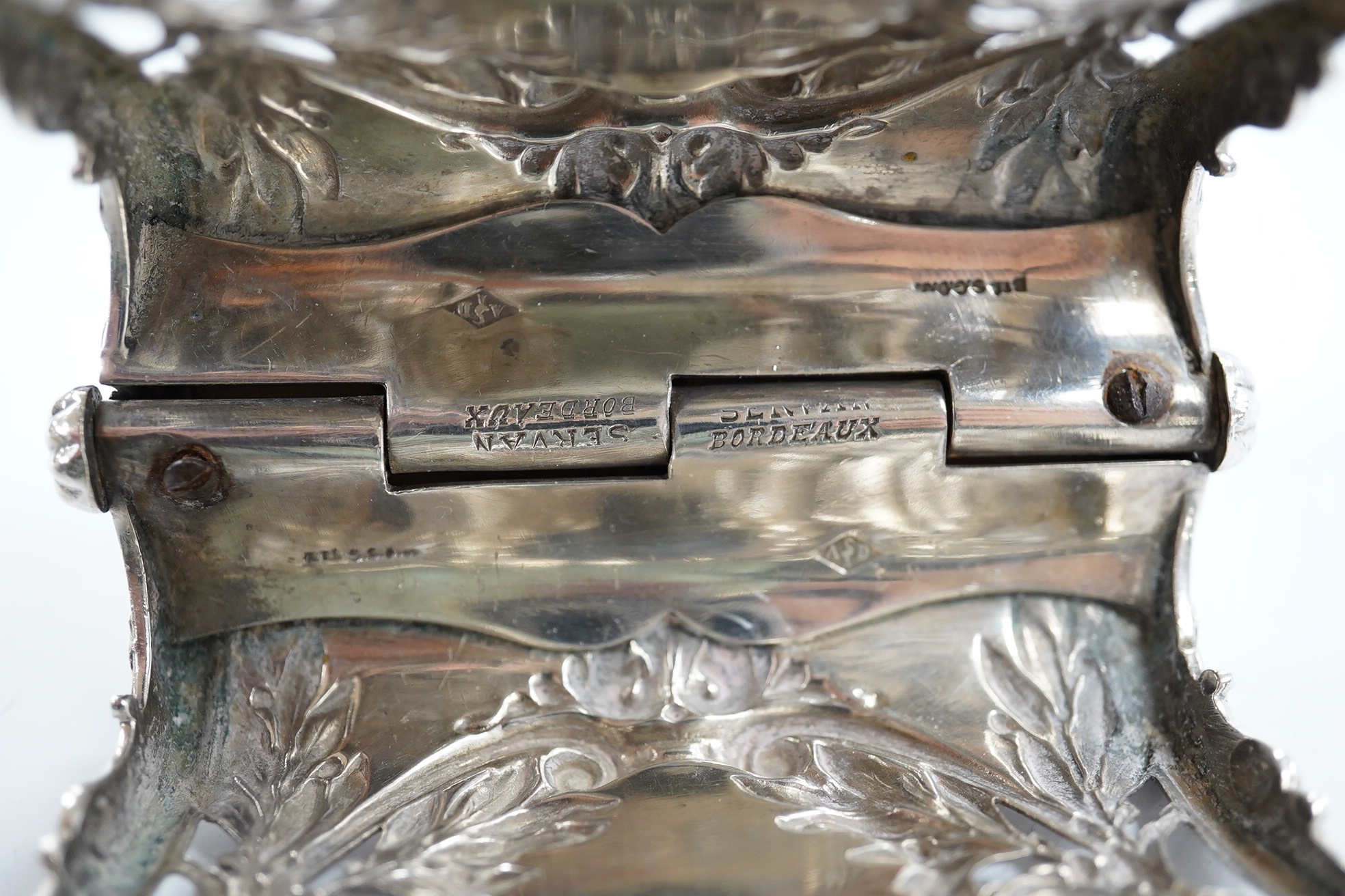A Danish sterling saucepan, with wood handle, by F. Hingelberg, diameter 95mm and a pair of French pierced plated serving tongs. Condition - poor to fair